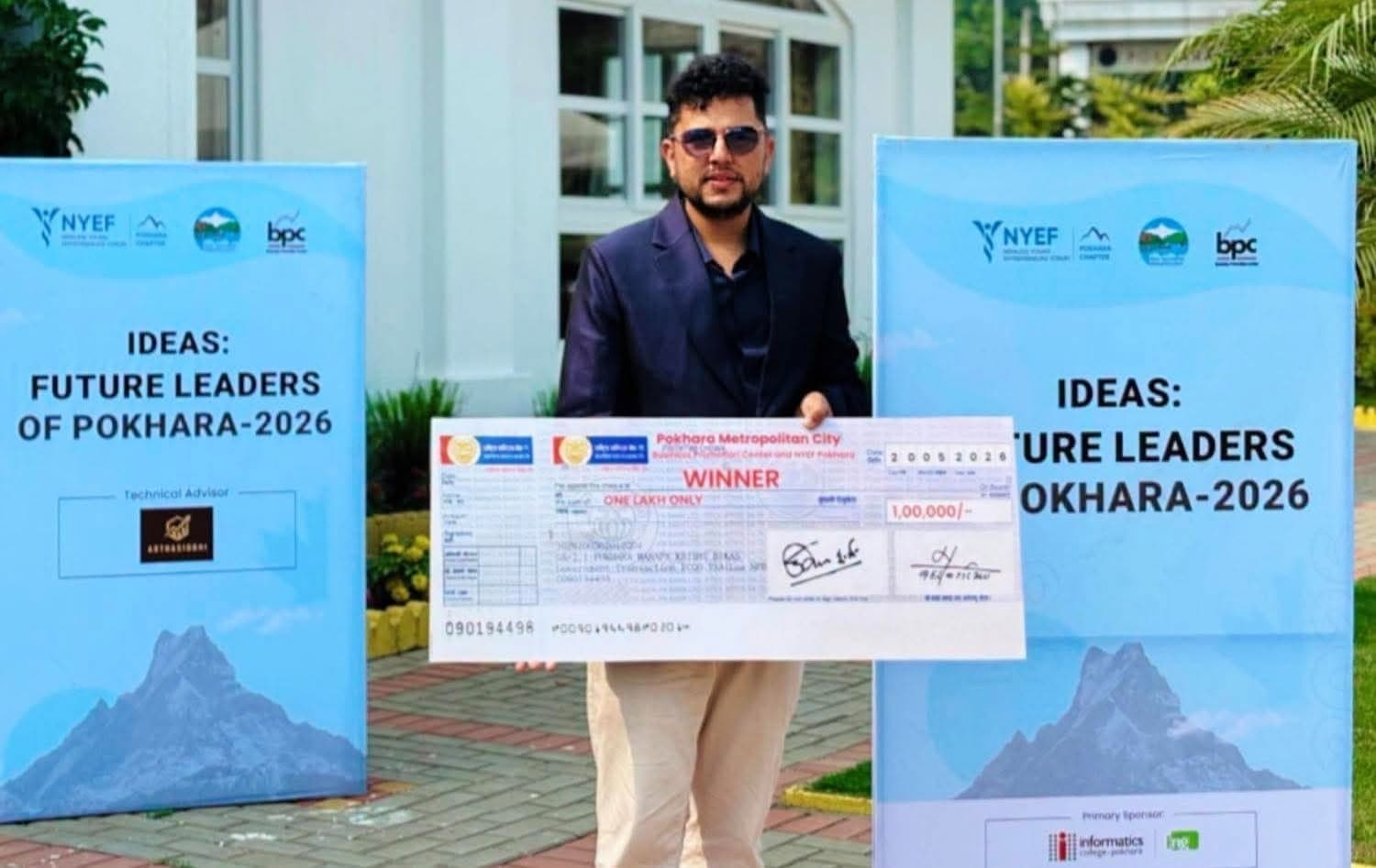 Rabin Paudel holding the winner’s cheque between two Ideas: Future Leaders of Pokhara 2026 banners